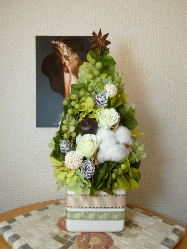 グリーンのミニツリー ミニバラとコットンをメインに、クリスマスが過ぎても飾れるようグリーンでまとめたミニツリー。花器には２種のリボンを貼りました。 唐沢野枝