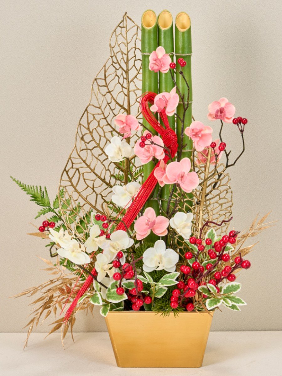 メッシュリーフ門松飾り プラべメタリックプラット(花器）にフォームをセットし、竹を真っすぐ並べて挿します。
前後にメッシュワイドリーフを挿し、花材はリーフのメッシュを隠さないように挿していきます。

作品サイズ(cm)　左： 株式会社東京堂