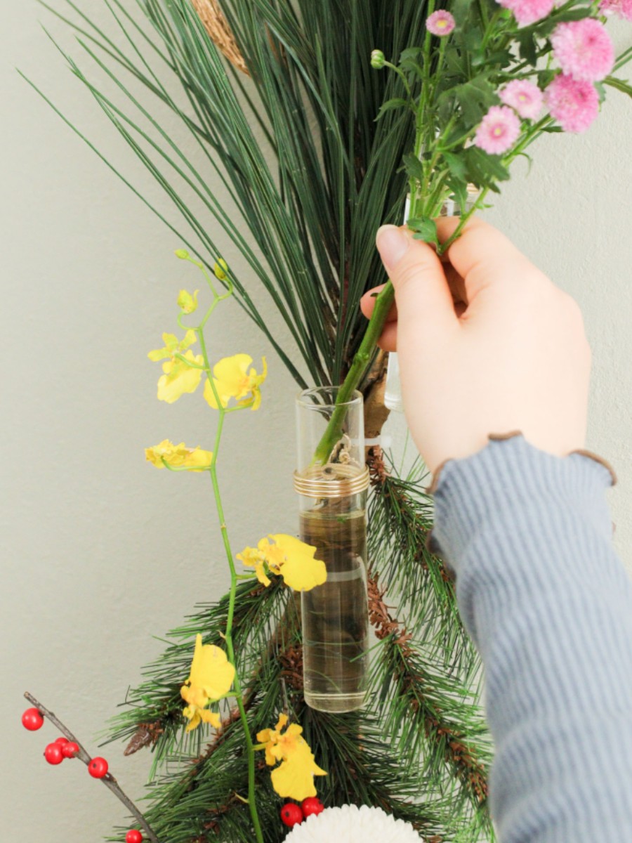 生花と造花のハイブリッドデザイン　ガラスチューブの迎春の一輪挿しのアイデア